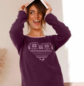 A woman is wearing a Blancheporte burgundy long sleeve top. She is smiling and looking to the side. She put a book on her head. She's happy.